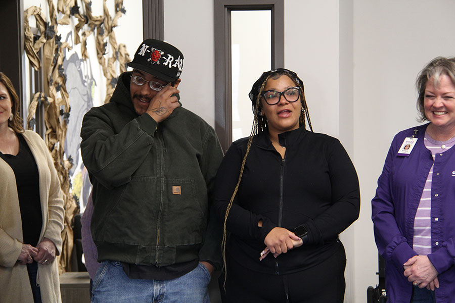 Alex Alvarez and Maggie Bradley address the crowd gathered at the Enhabit office during a pet supplies donation drive in honor of their late daughter.