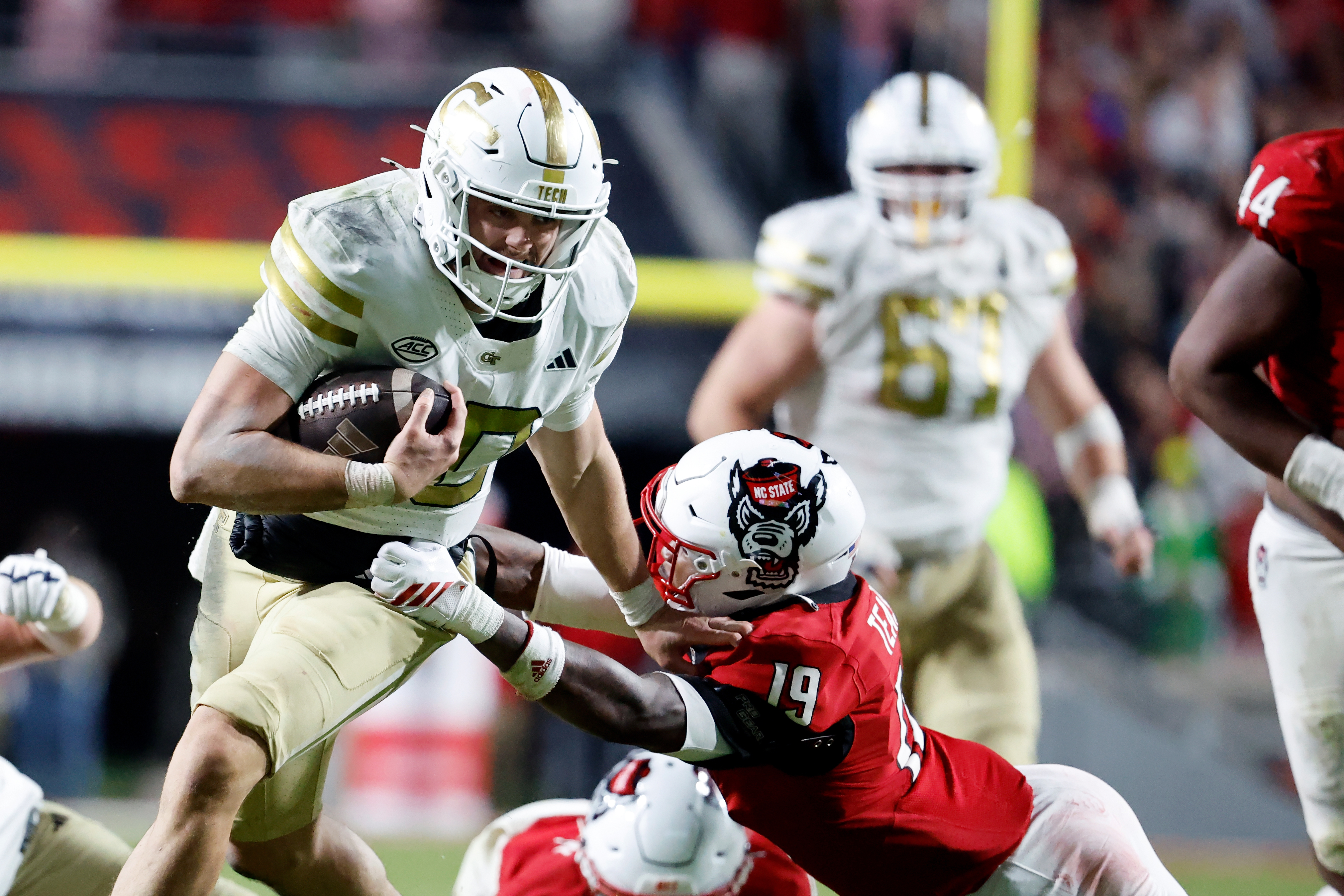Georgia Tech quarterback Haynes King (10) tries to break away from North Carolina State safety Tristan Teasdell (19) during the second half of an NCAA college football game in Raleigh, N.C., Saturday, Nov. 1, 2025.