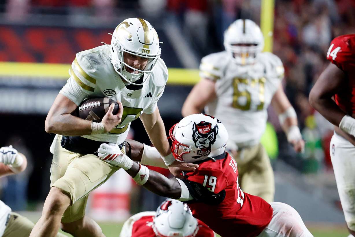 Georgia Tech quarterback Haynes King (10) tries to break away from North Carolina State safety Tristan Teasdell (19) during the second half of an NCAA college football game in Raleigh, N.C., Saturday, Nov. 1, 2025.