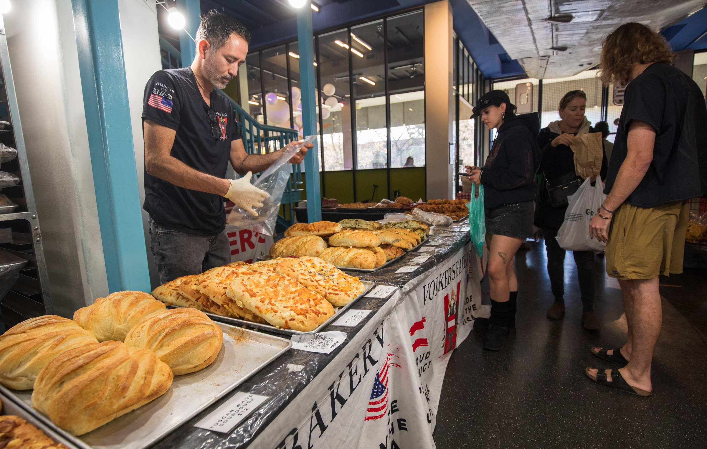 People purchase bread from Volker's Bakery at the Downtown Farmers Winter Market at the old Leonardo building in Salt Lake City on Saturday.