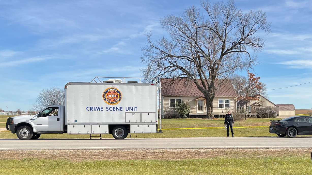 A crime scene truck parked in front of the home where a domestic violence incident resulted in multiple casualties, Saturday, in Carbondale, Kan. Four law enforcement officers were shot in the incident.