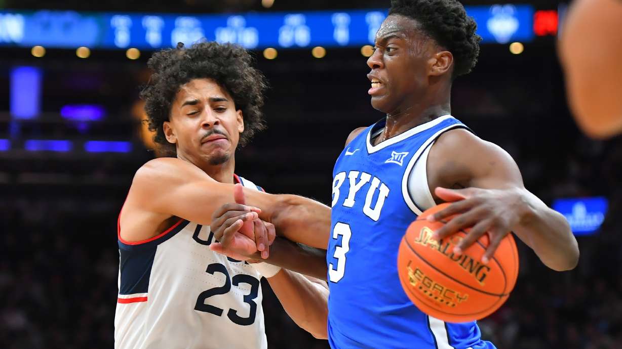 BYU forward AJ Dybantsa (3) drives toward the basket as UConn forward Jayden Ross (23) defends in the first half of an NCAA college basketball game, Saturday, Nov. 15, 2025, in Boston.