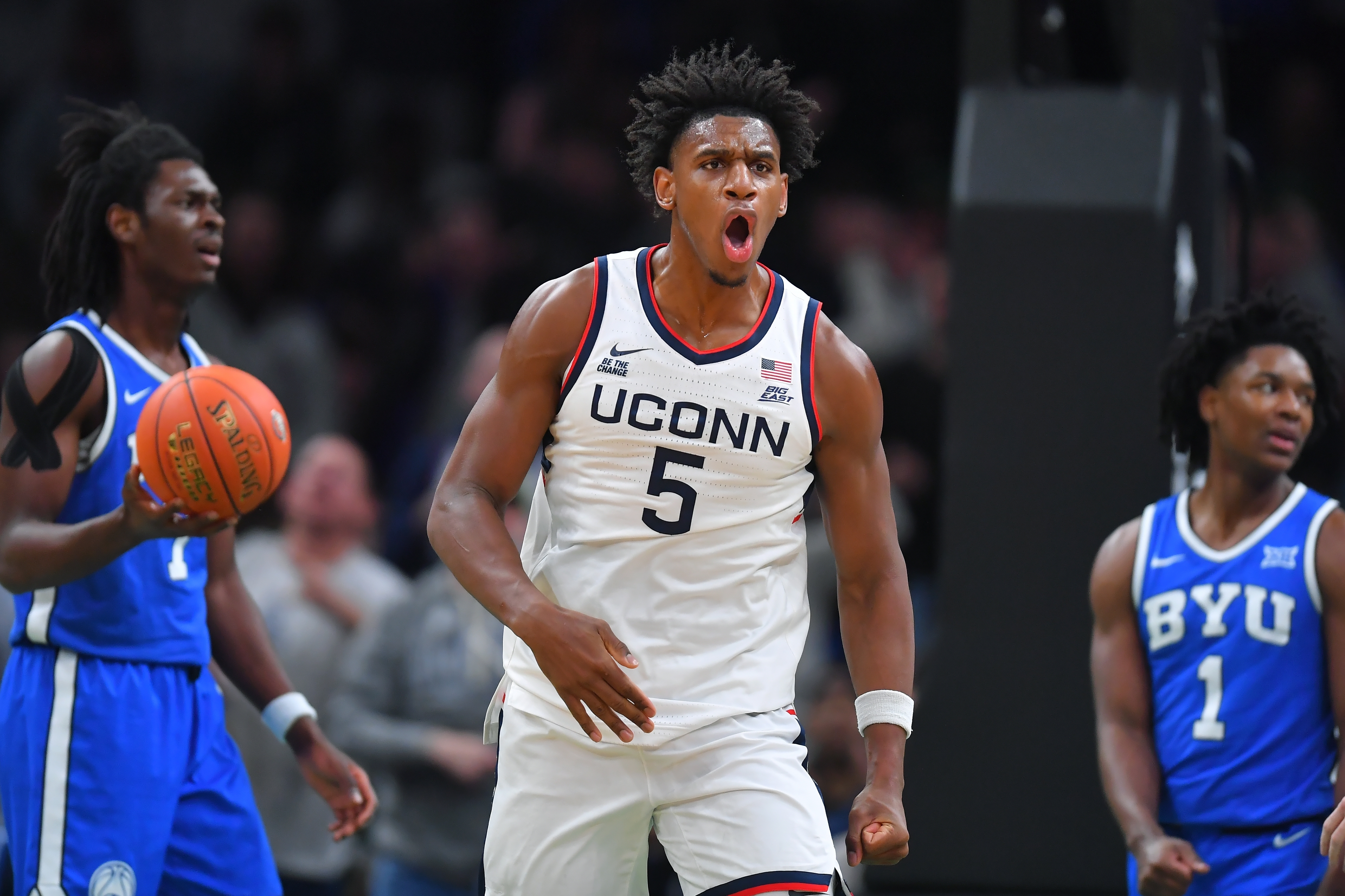 UConn forward Tarris Reed Jr., center, celebrates in front of BYU forward Khadim Mboup, left, and guard Robert Wright III after scoring in the first half of an NCAA college basketball game, Saturday, Nov. 15, 2025, in Boston. 