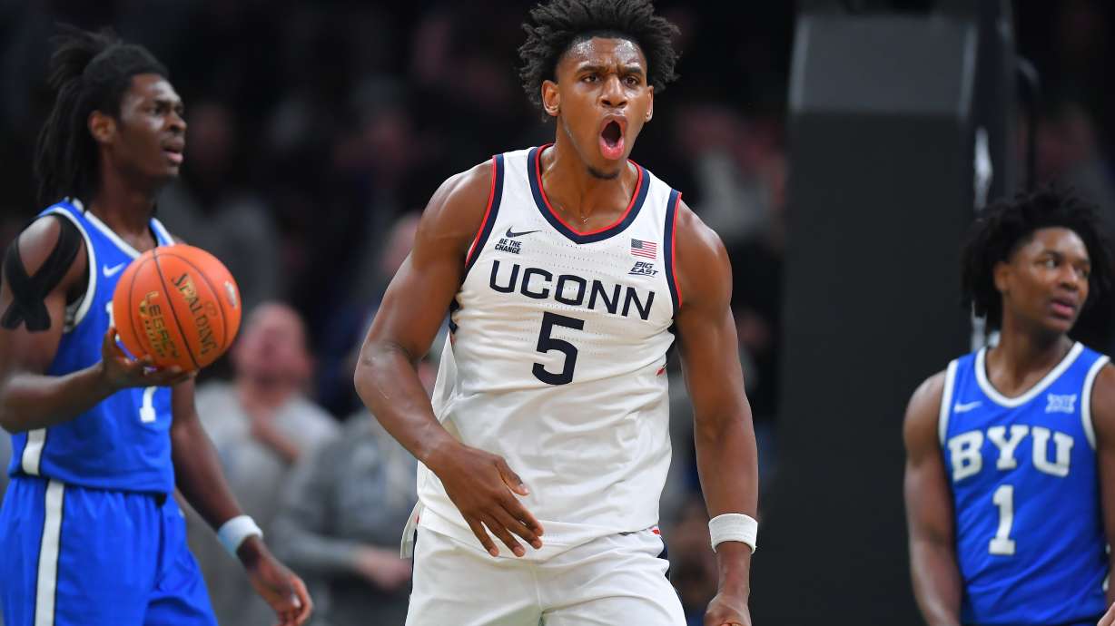 UConn forward Tarris Reed Jr., center, celebrates in front of BYU forward Khadim Mboup, left, and guard Robert Wright III after scoring in the first half of an NCAA college basketball game, Saturday, Nov. 15, 2025, in Boston.