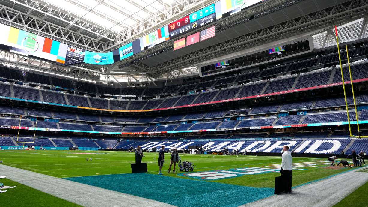 Workers prepare the field at the Santiago Bernabeu stadium ahead of an NFL game between the Miami Dolphins and Washington Commanders in Madrid, Spain, Friday, Nov. 14, 2025.
