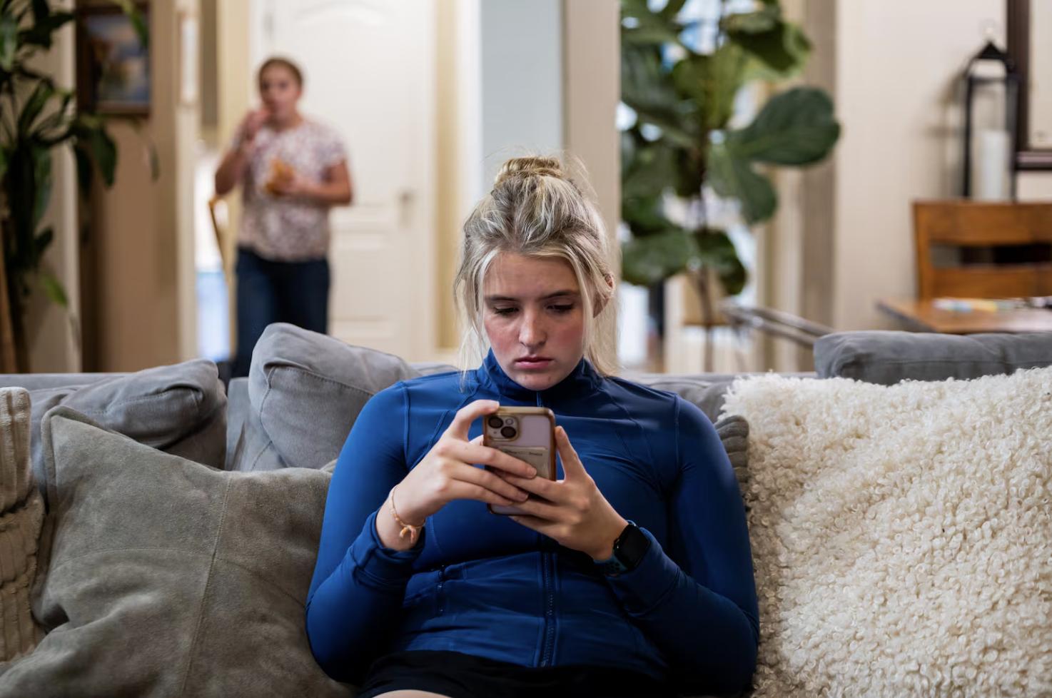 Becca Long, 17, checks her phone at her home in Bountiful on Nov. 6.