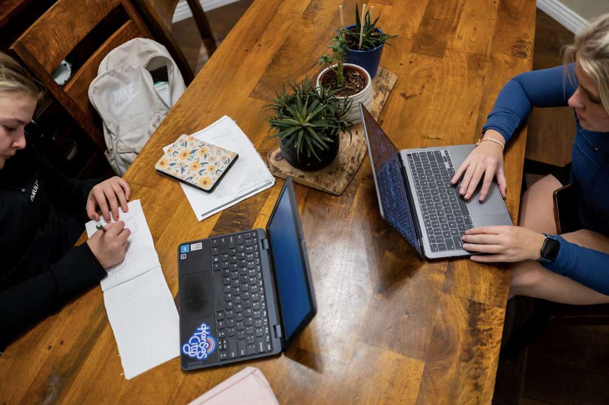 Caroline Long, 13, left, and sister Becca Long, 17, right, do work for school at their home in Bountiful on Nov. 6.