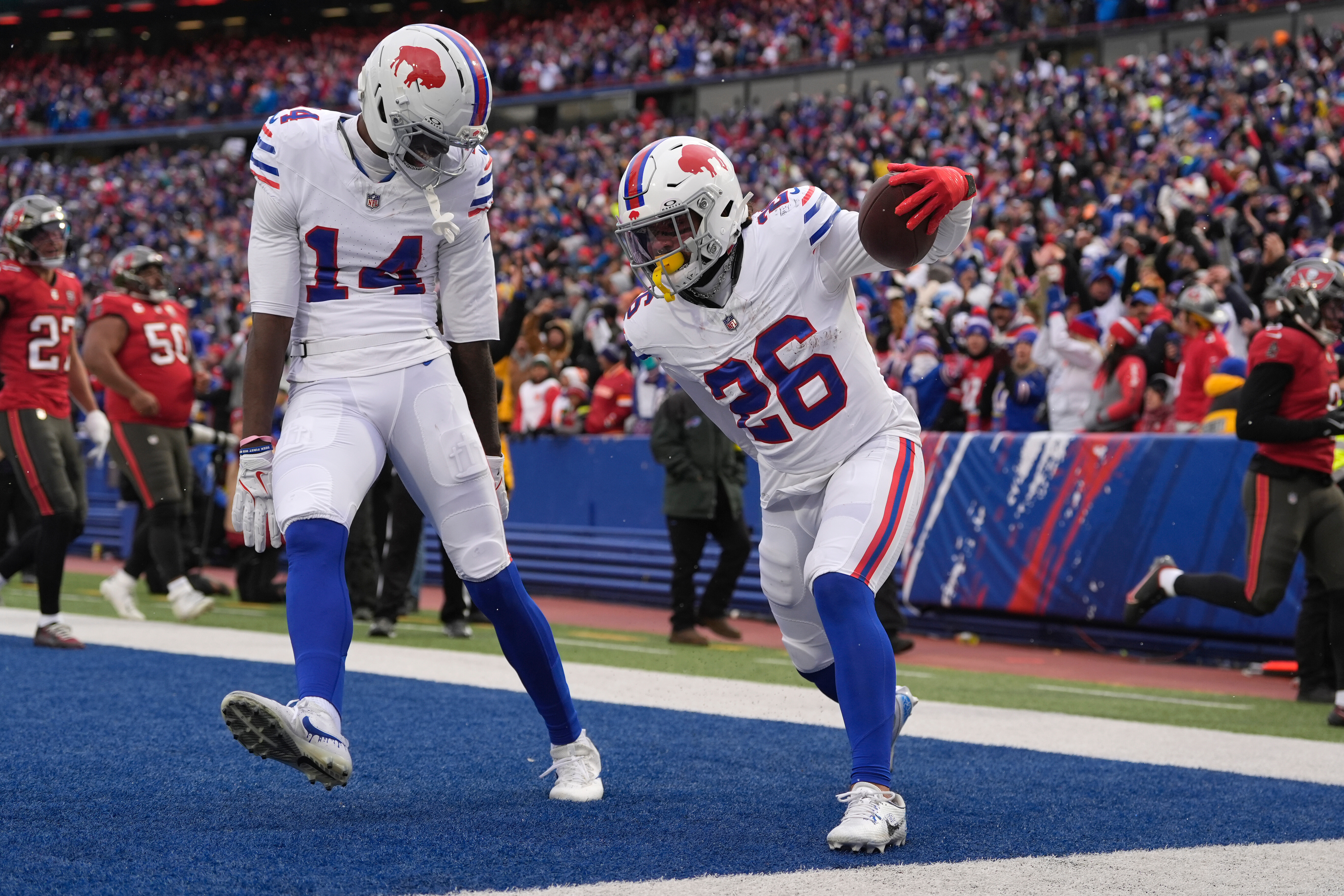 Buffalo Bills running back Ty Johnson (26) celebrates with wide receiver Tyrell Shavers (14) after scoring a touchdown against the Tampa Bay Buccaneers during the first half of an NFL football game, Sunday, Nov. 16, 2025, in Orchard Park, N.Y.