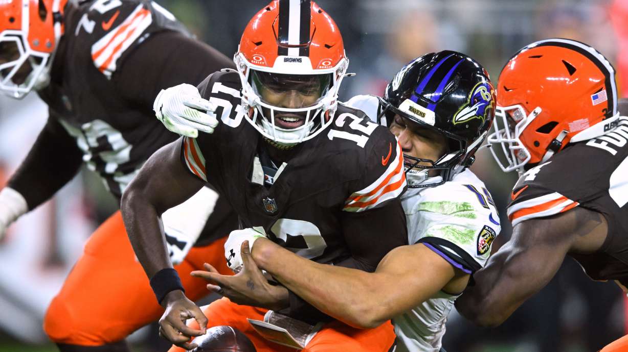 Cleveland Browns quarterback Shedeur Sanders (12) is sacked by Baltimore Ravens safety Kyle Hamilton (14) in the second half of an NFL football game in Cleveland, Sunday, Nov. 16, 2025.