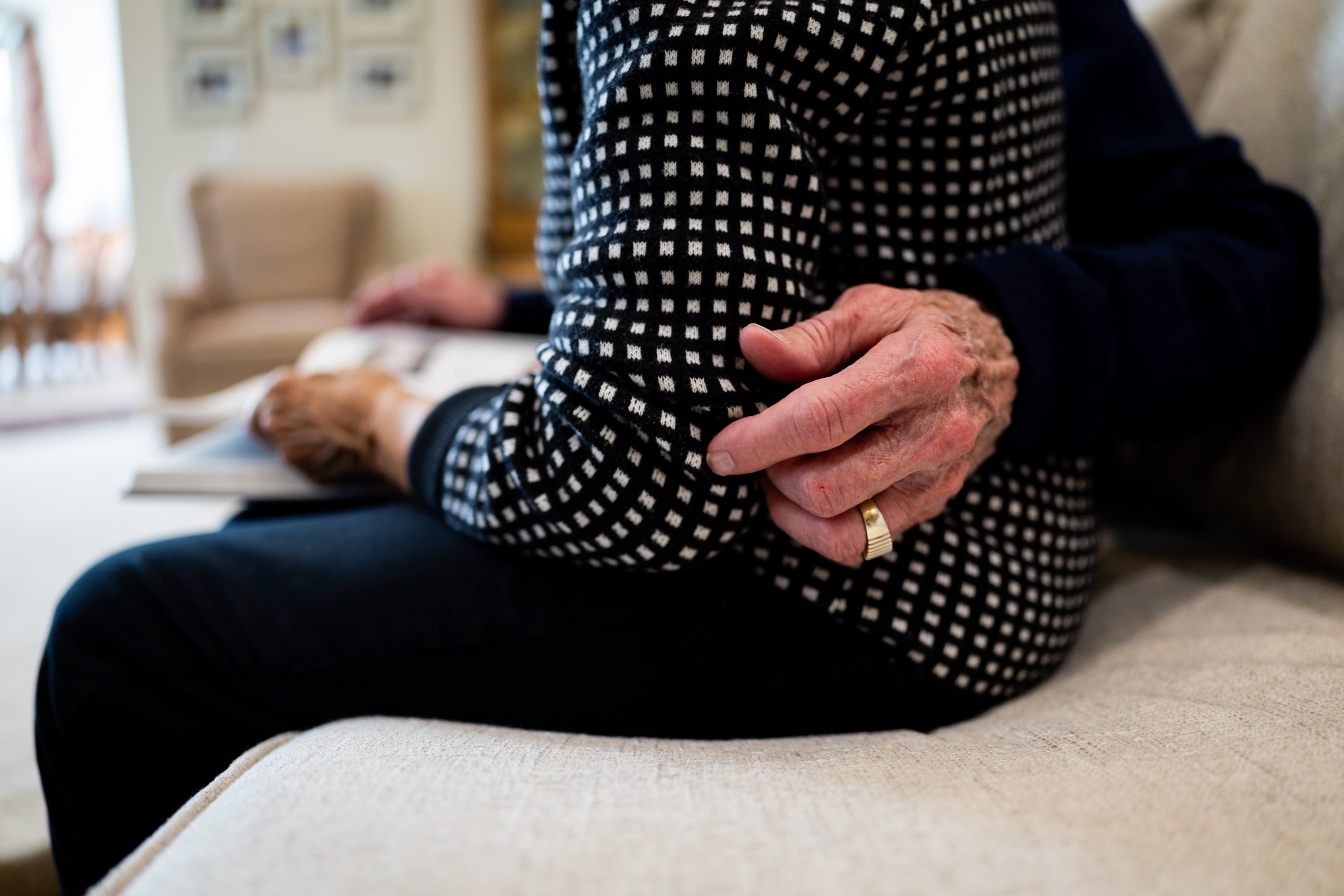 Kelvyn Cullimore wraps his arm around wife Kay Cullimore as the pair poses while looking at their personal history book they made in 2021 at their home in Cottonwood Heights on Nov. 5.