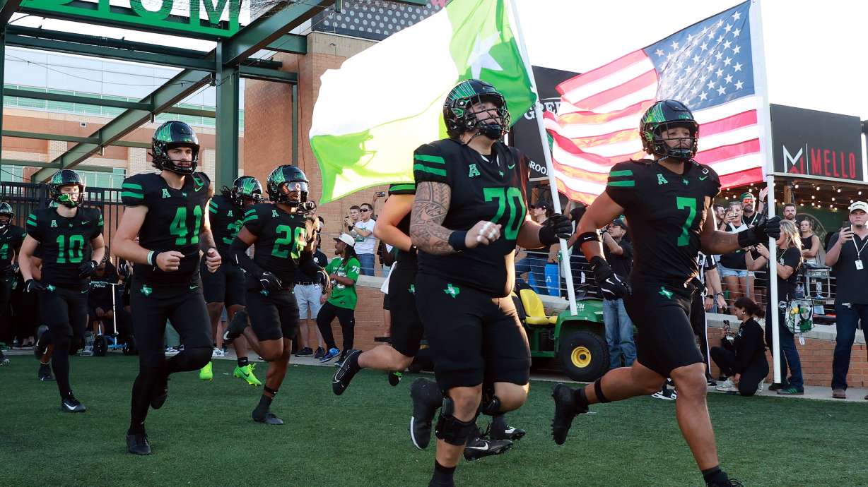 FILE - North Texas offensive lineman Tay Yanta II (70) and North Texas linebacker Shane Whitter (7) lead the team onto the field before an NCAA college football game against South Florida Oct. 10, 2025, in Denton, Texas.