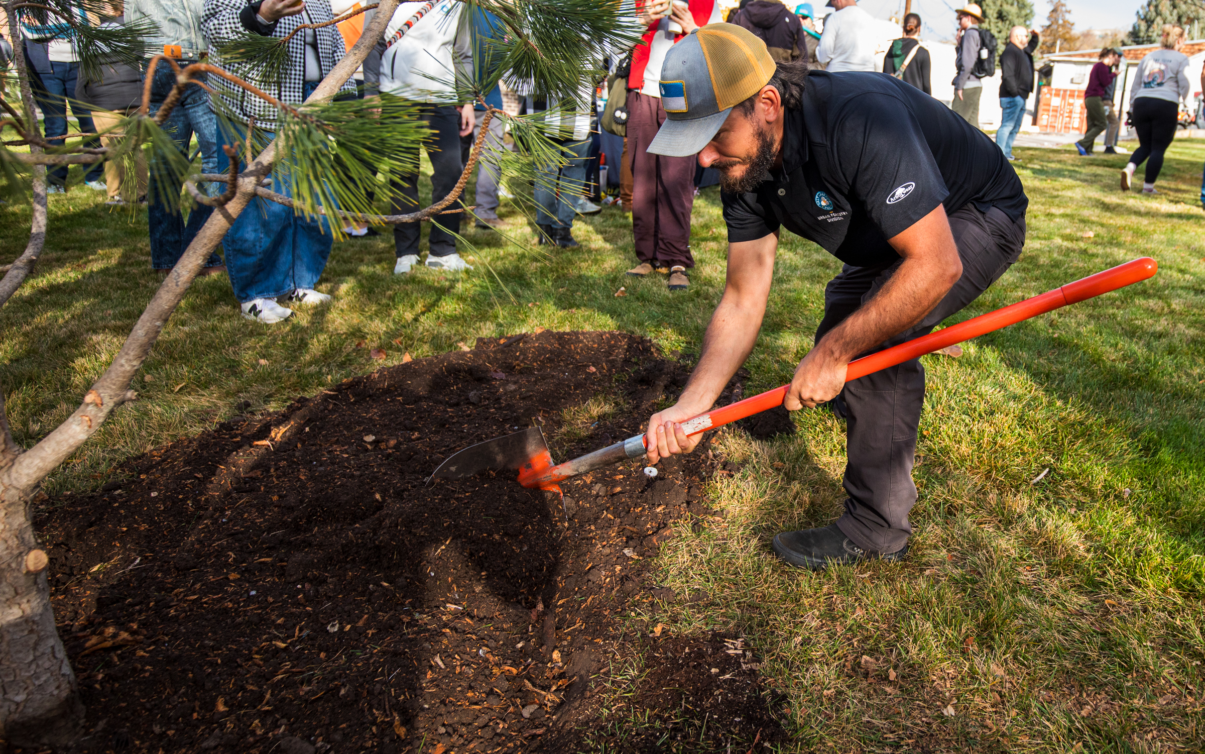 Nate Orbach, supervisor for Salt Lake City Urban Forestry, demonstrates a tree planting to volunteers at the Salt Lake City Cemetery on Saturday.