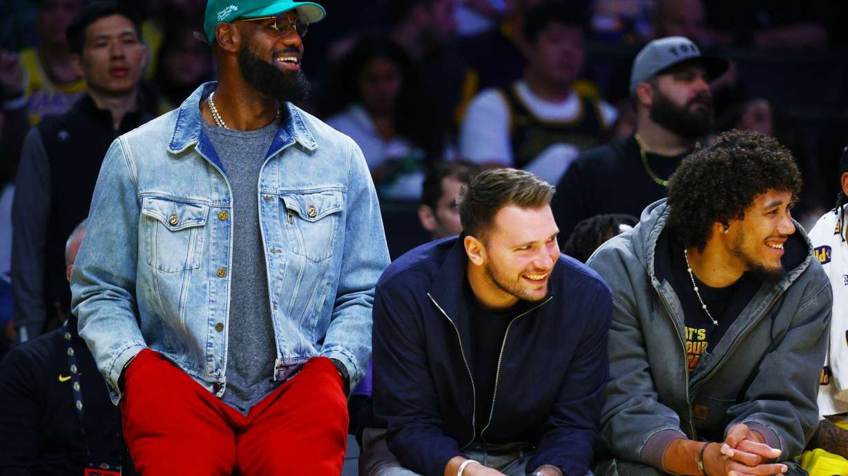 Los Angeles Lakers forward LeBron James (23) and Los Angeles Lakers guard Luka Doncic (77) watch from the bench during the second half of an NBA basketball game against the Portland Trail Blazers, Monday, Oct. 27, 2025, in Los Angeles.