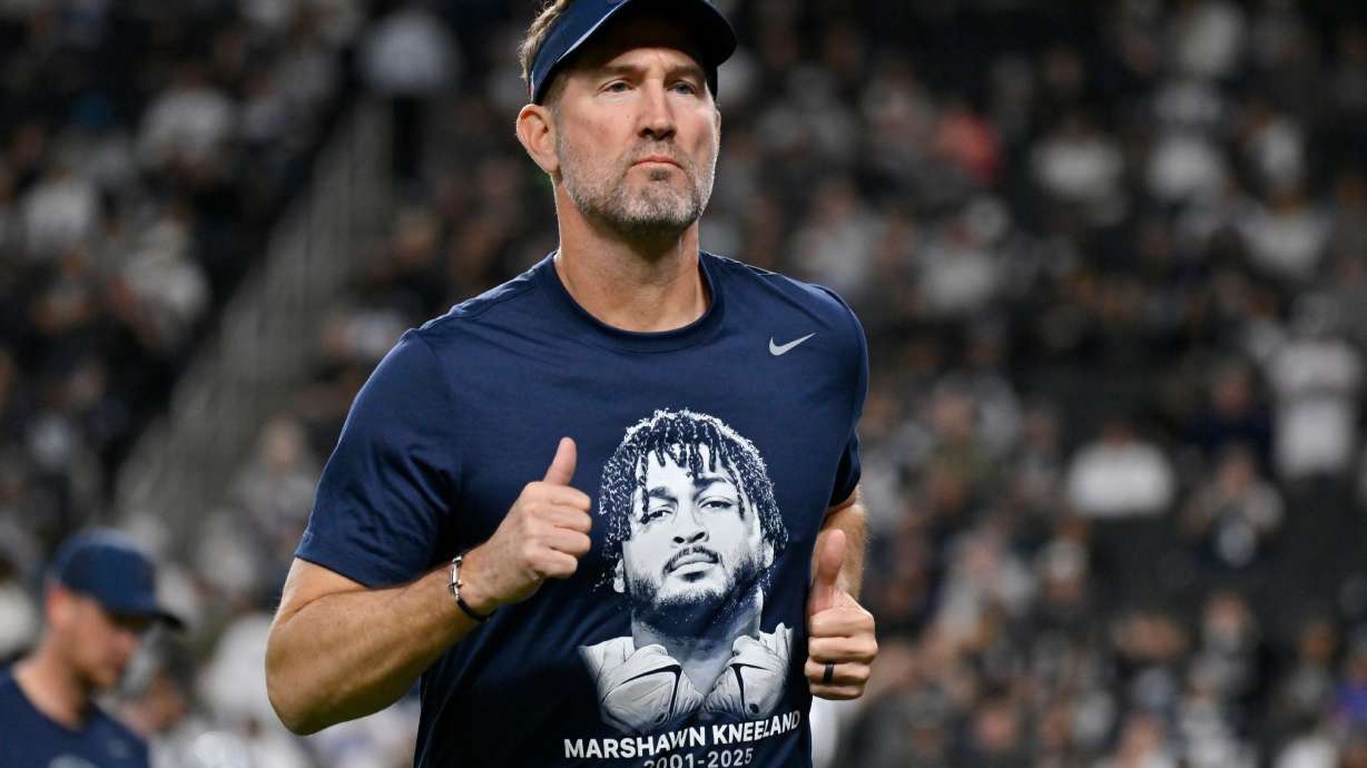 Dallas Cowboys head coach Brian Schottenheimer wears a tribute t-shirt of Cowboys' Marshawn Kneeland prior to an NFL football game against the Las Vegas Raiders Monday, Nov. 17, 2025, in Las Vegas, in memory of Kneeland who passed away earlier this month.
