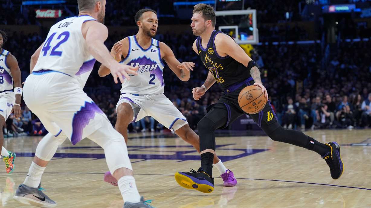 Los Angeles Lakers guard Luka Doncic (77) is defended by Utah Jazz forward Kevin Love (42) and forward Kyle Anderson (2) during the second half of an NBA basketball game Tuesday, Nov. 18, 2025, in Los Angeles.