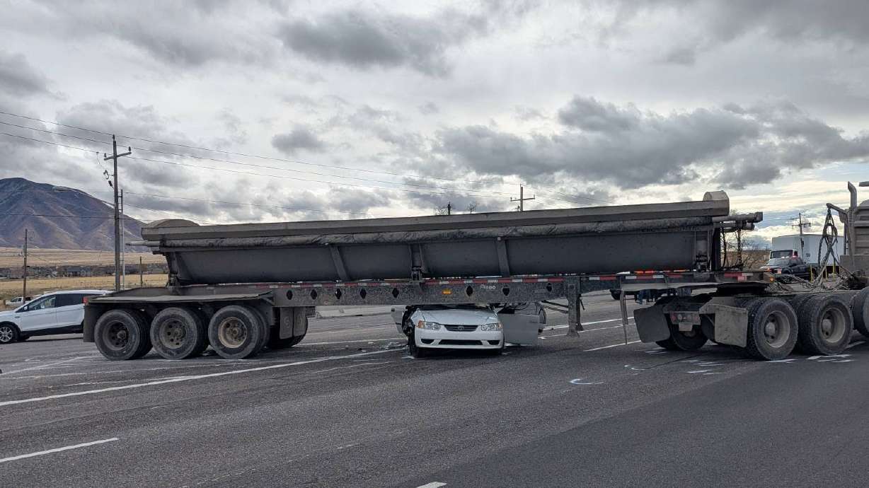 Two people were injured after their car got wedged underneath a semitruck trailer in Tooele County Wednesday.