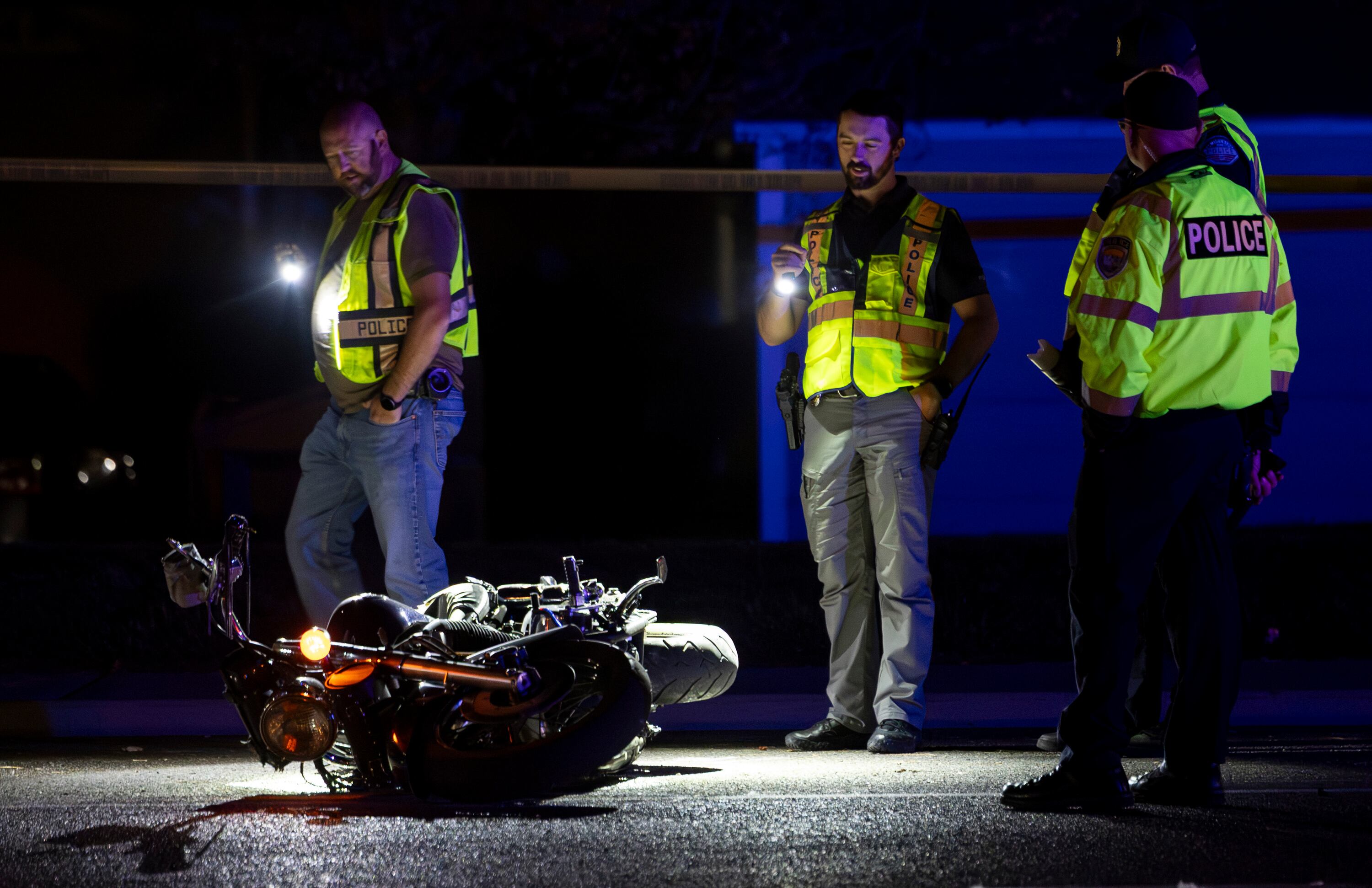 Police officers inspect a motorcycle laying in the road after it was involved in a collision on 5400 South near Taylorsville High School in Taylorsville on Nov. 2. The driver of the motorcycle was killed after being struck by a car that was fleeing the scene of a separate accident.