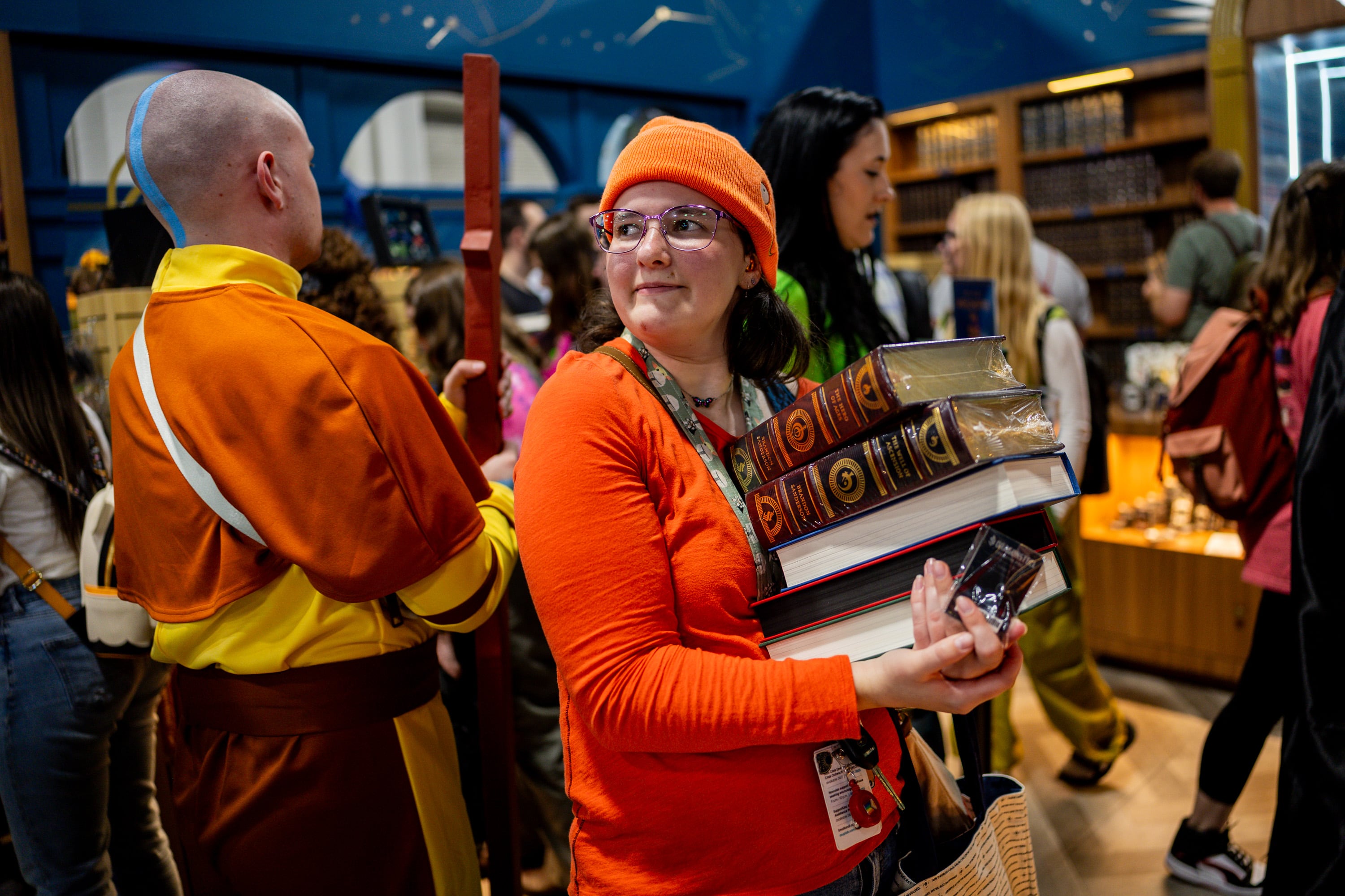 Madison Morgan, from Salt Lake City, center, shops at author Brandon Sanderson’s Dragonsteel Books vendor booth at FanX Salt Lake Pop Culture and Comic Convention at the Salt Palace Convention Center in Salt Lake City, Sept. 26, 2025.