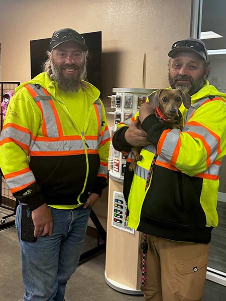 Two men with Idaho Transportation Department holding Tessa after finding her along I-15 near Spencer, Idaho, Monday. Tessa is expected to reunite with her family this weekend.
