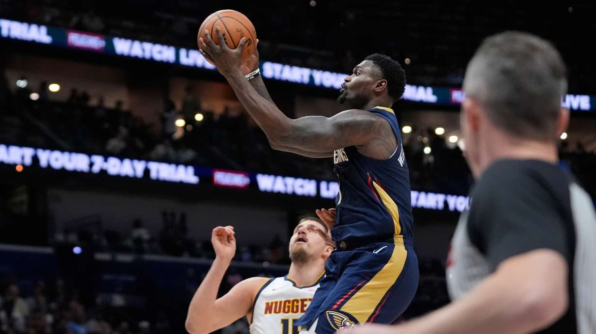 New Orleans Pelicans forward Zion Williamson (1) goes to the basket over Denver Nuggets center Nikola Jokic (15) in the first half of an NBA basketball game, Wednesday, Nov. 19, 2025, in New Orleans.