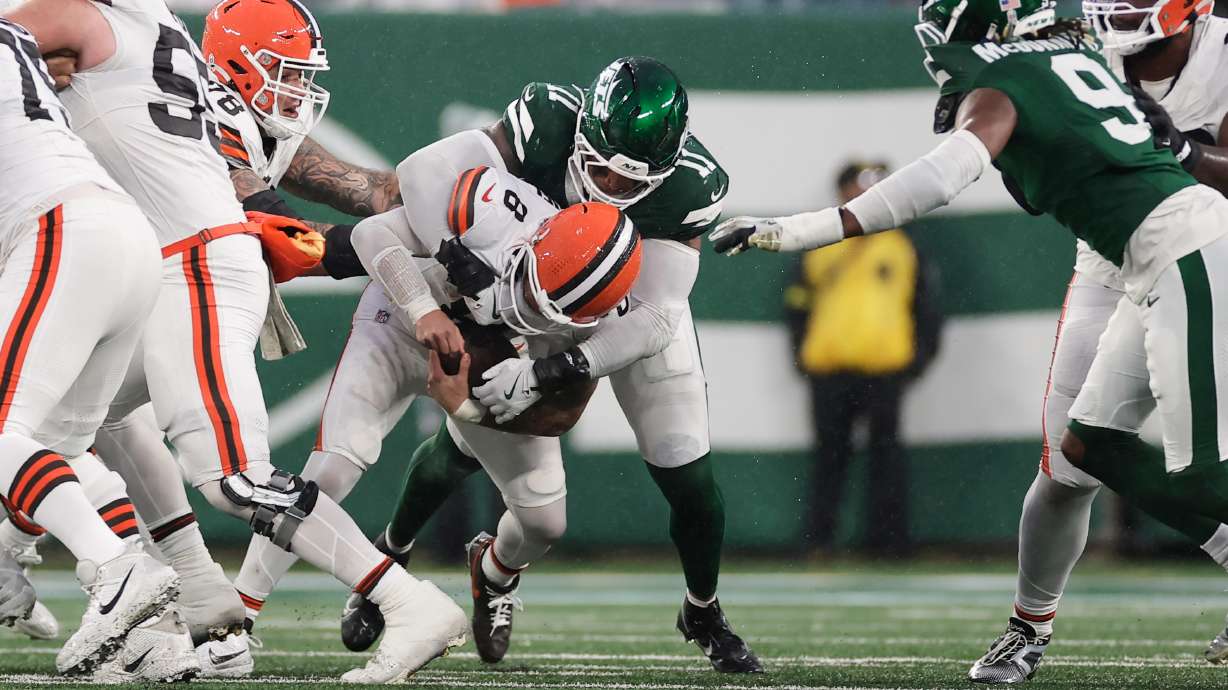 Cleveland Browns quarterback Dillon Gabriel (8) is sacked by New York Jets linebacker Jermaine Johnson (11) in the second half of an NFL football game, Sunday, Nov. 9, 2025, in East Rutherford, N.J.