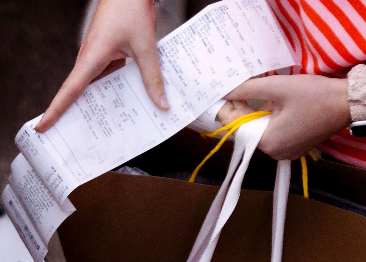 A consumer organizes her receipts while shopping at City Creek Center in Salt Lake City on Friday, Nov. 29, 2024.