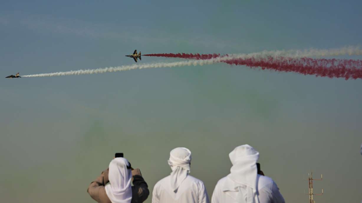 Emirati men take photos of Fursan Al Emarat, the aerobatics demonstration team of the United Arab Emirates Air Force during the Dubai Air Show in Dubai, United Arab Emirates, Tuesday.