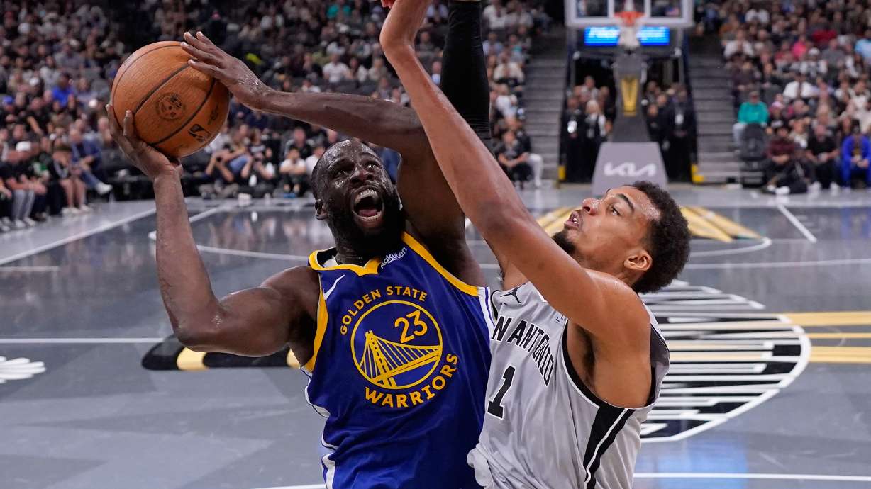 Golden State Warriors forward Draymond Green (23) drives to the basket against San Antonio Spurs forward Victor Wembanyama (1) during the second half of an NBA Cup basketball game in San Antonio, Friday, Nov. 14, 2025.