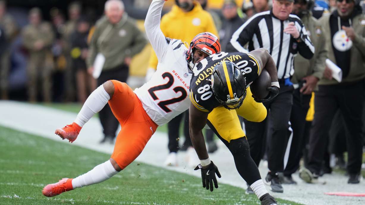 Pittsburgh Steelers tight end Darnell Washington (80) avoids a tackle by Cincinnati Bengals safety Geno Stone (22) during the first half of an NFL football game Sunday, Nov. 16, 2025, in Pittsburgh.
