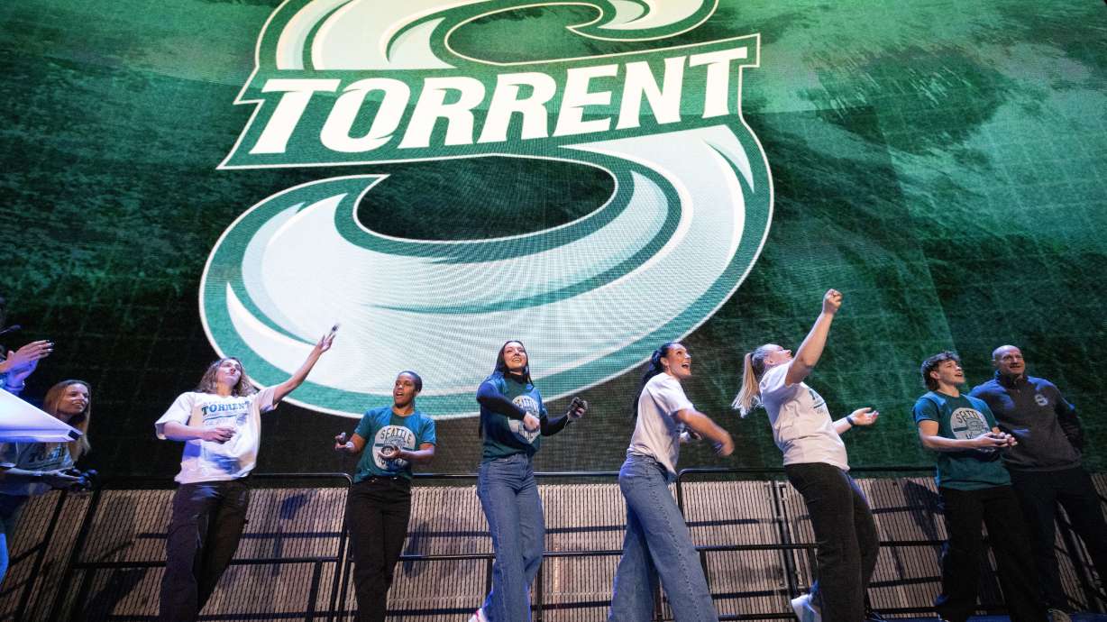 Seattle Torrent members toss gifts to the crowd during an event unveiling the PWHL hockey team's new logo and name, Thursday, Nov. 6, 2025, in Seattle.