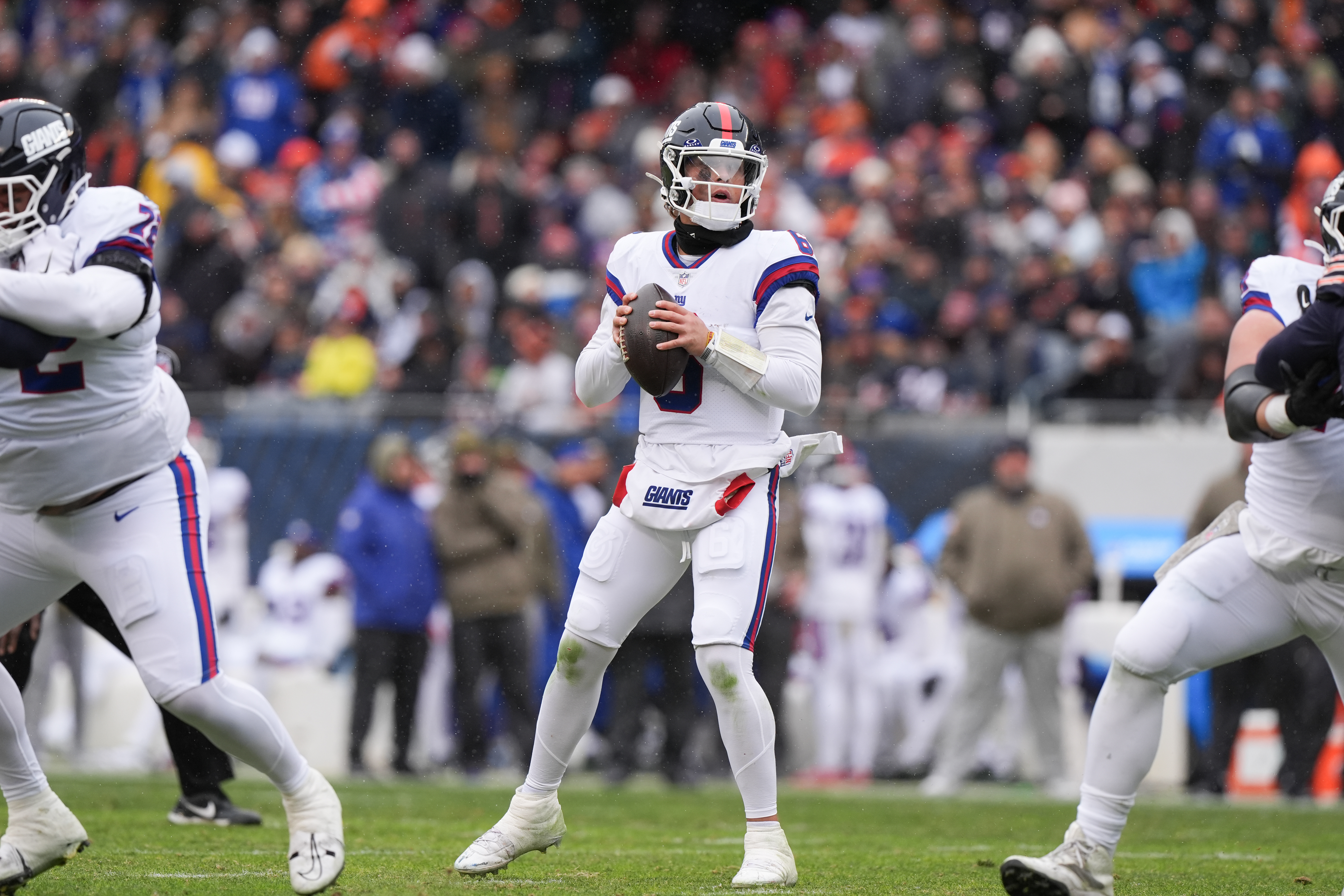 New York Giants quarterback Jaxson Dart, center, looks to throw during the first half of an NFL football game against the Chicago Bears, Sunday, Nov. 9, 2025, in Chicago. 