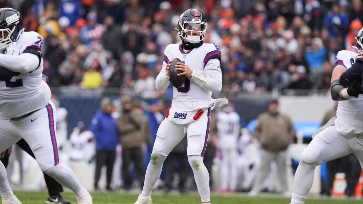 New York Giants quarterback Jaxson Dart, center, looks to throw during the first half of an NFL football game against the Chicago Bears, Sunday, Nov. 9, 2025, in Chicago.