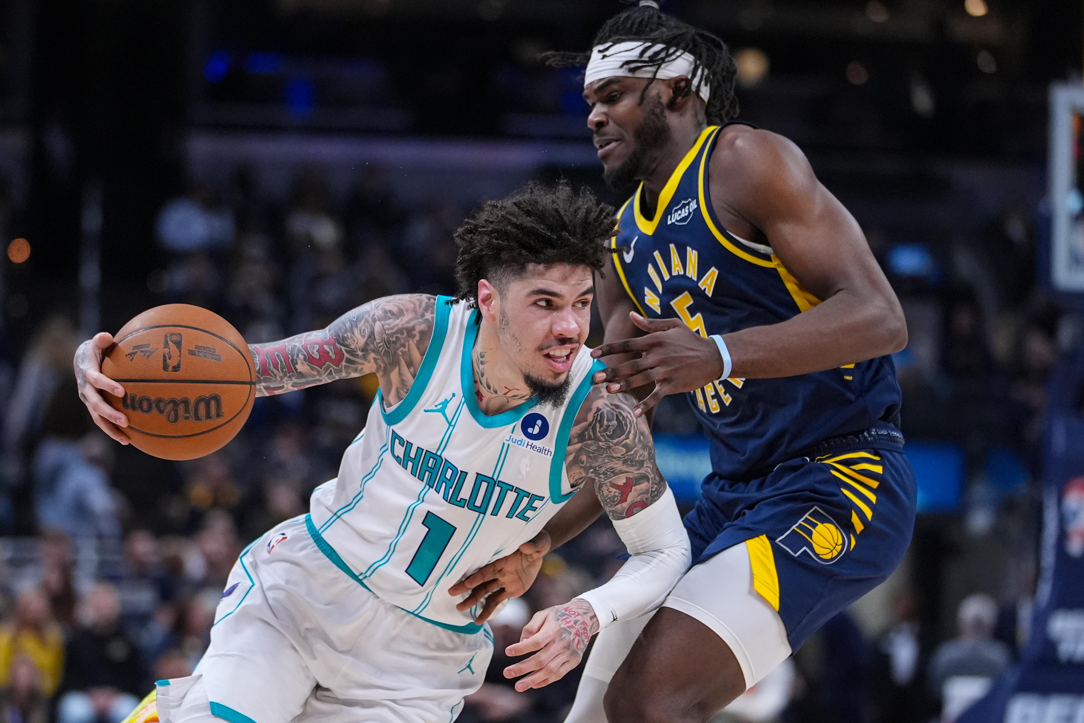 Charlotte Hornets guard Lamelo Ball (1) drives on Indiana Pacers forward Jarace Walker (5) during the first half of an NBA basketball game in Indianapolis, Wednesday, Nov. 19, 2025. 