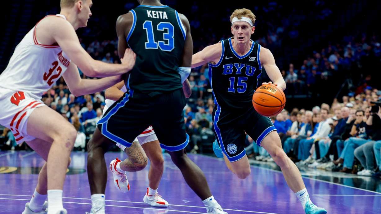 Richie Saunders drives behind a screen from Keba Keita in BYU's game against Wisconsin at the Delta Center.