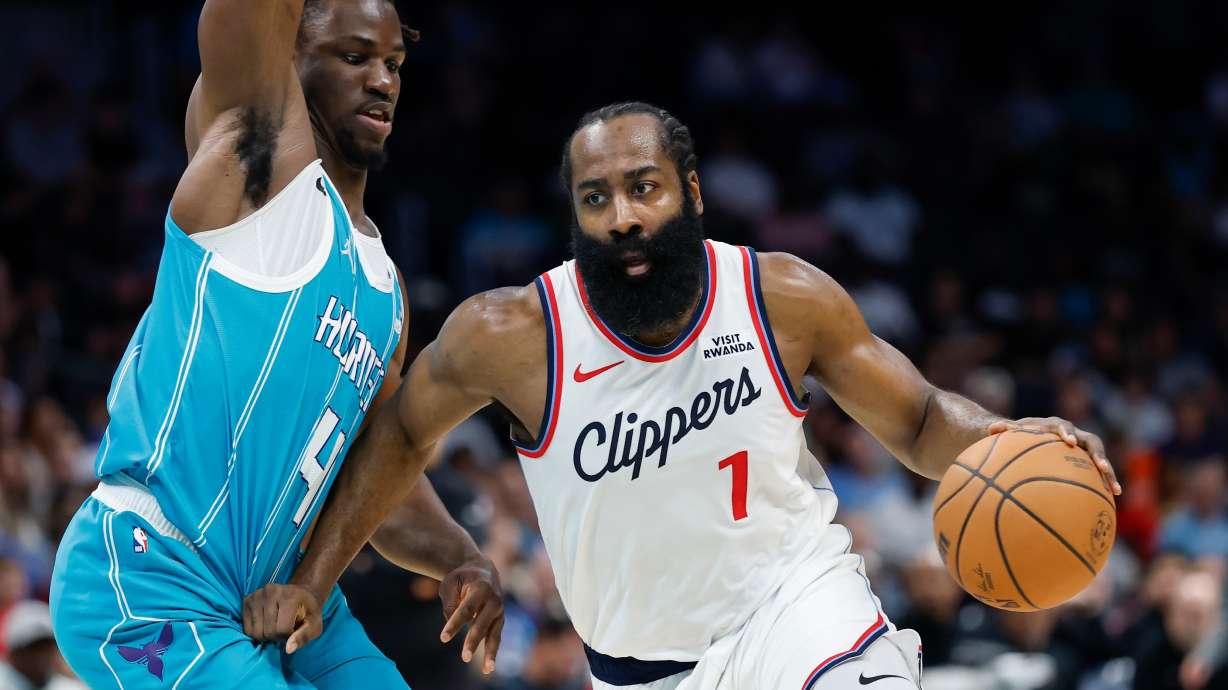 Los Angeles Clippers guard James Harden, right, drives to the basket against Charlotte Hornets guard Sion James during the first half of an NBA basketball game in Charlotte, N.C., Saturday, Nov. 22, 2025.