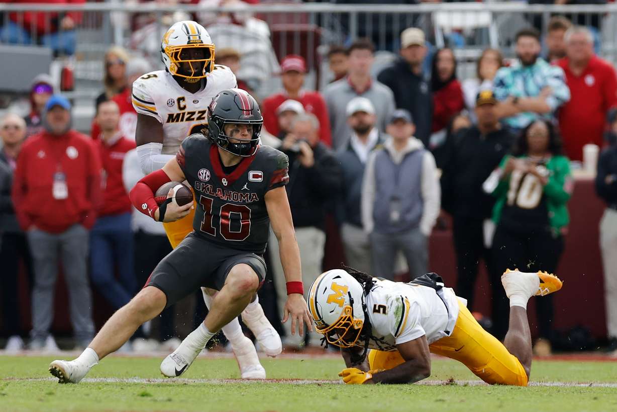 Oklahoma quarterback John Mateer (10) runs the ball past Missouri linebacker Khalil Jacobs (5) during the second half of an NCAA college football game Saturday, Nov. 22, 2025, in Norman, Okla.