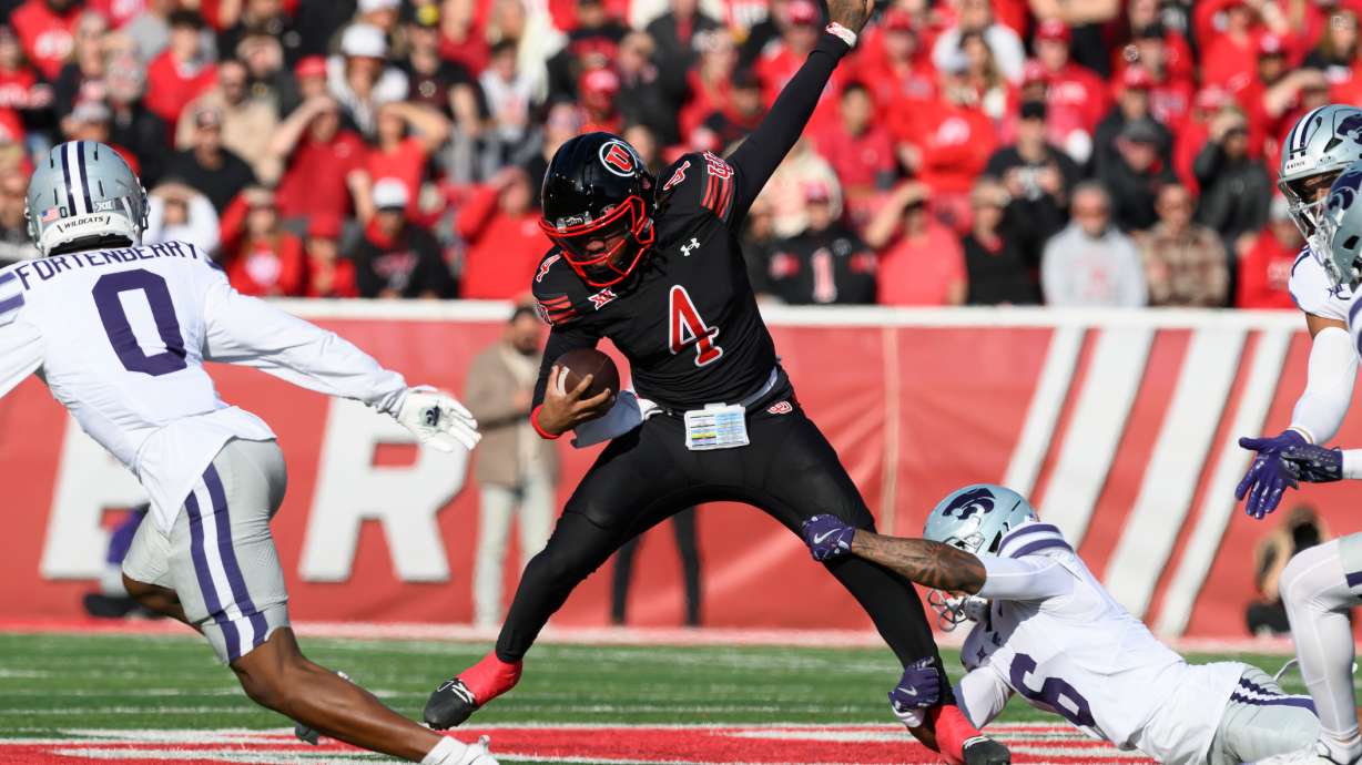 Utah quarterback Devon Dampier (4) is tackled by Kansas State defensive back Qua Moss, bottom right, during the first half of an NCAA college football game, Saturday, Nov. 22, 2025, in Salt Lake City.