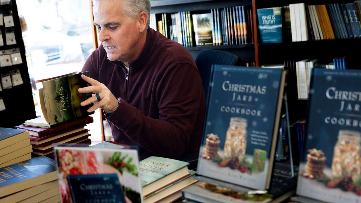 Author Jason Wright signs one of his books at Deseret Book in Spanish Fork on Nov. 6.