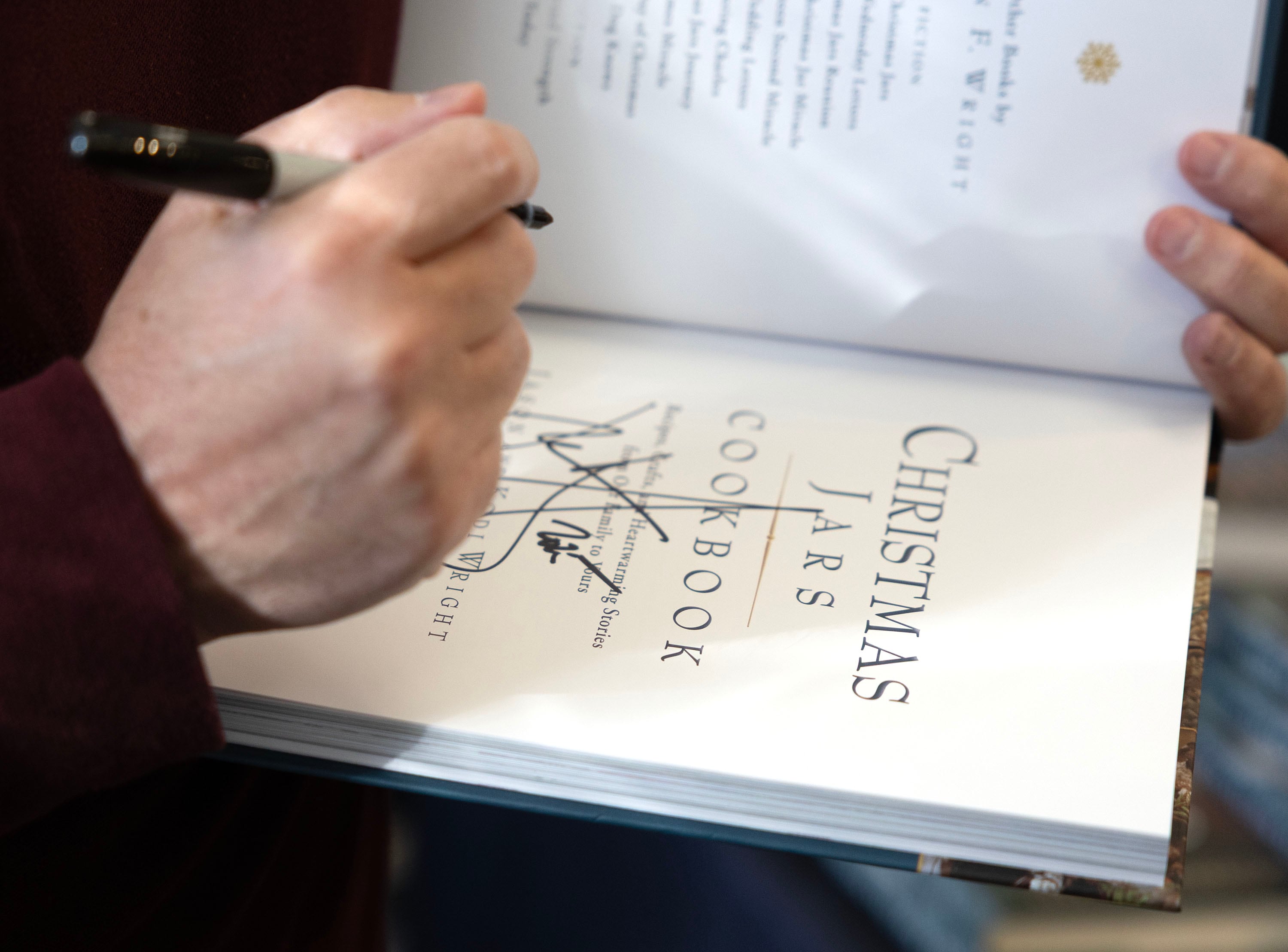 Author Jason Wright signs one of his books at Deseret Book in Spanish Fork on Nov. 6.