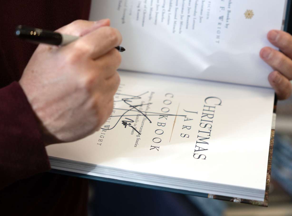 Author Jason Wright signs one of his books at Deseret Book in Spanish Fork on Nov. 6.
