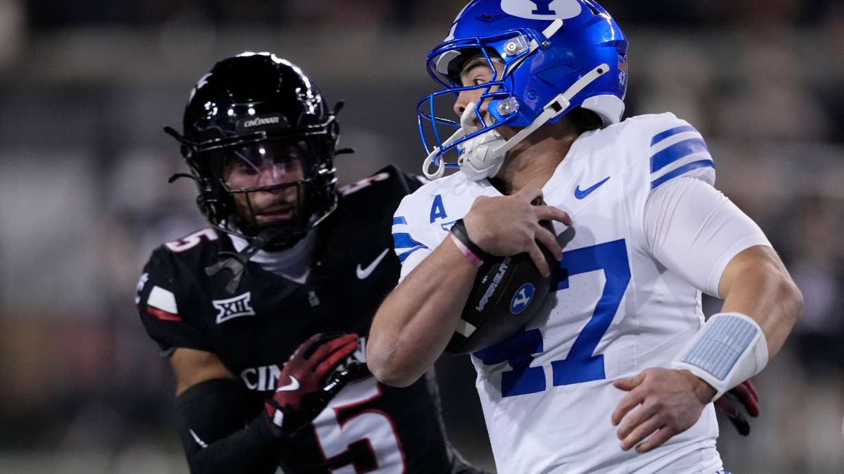 BYU quarterback Bear Bachmeier (47) eyes Cincinnati safety Christian Harrison (5) as he runs with the ball during the first half of an NCAA college football game Saturday, Nov. 22, 2025, in Cincinnati.