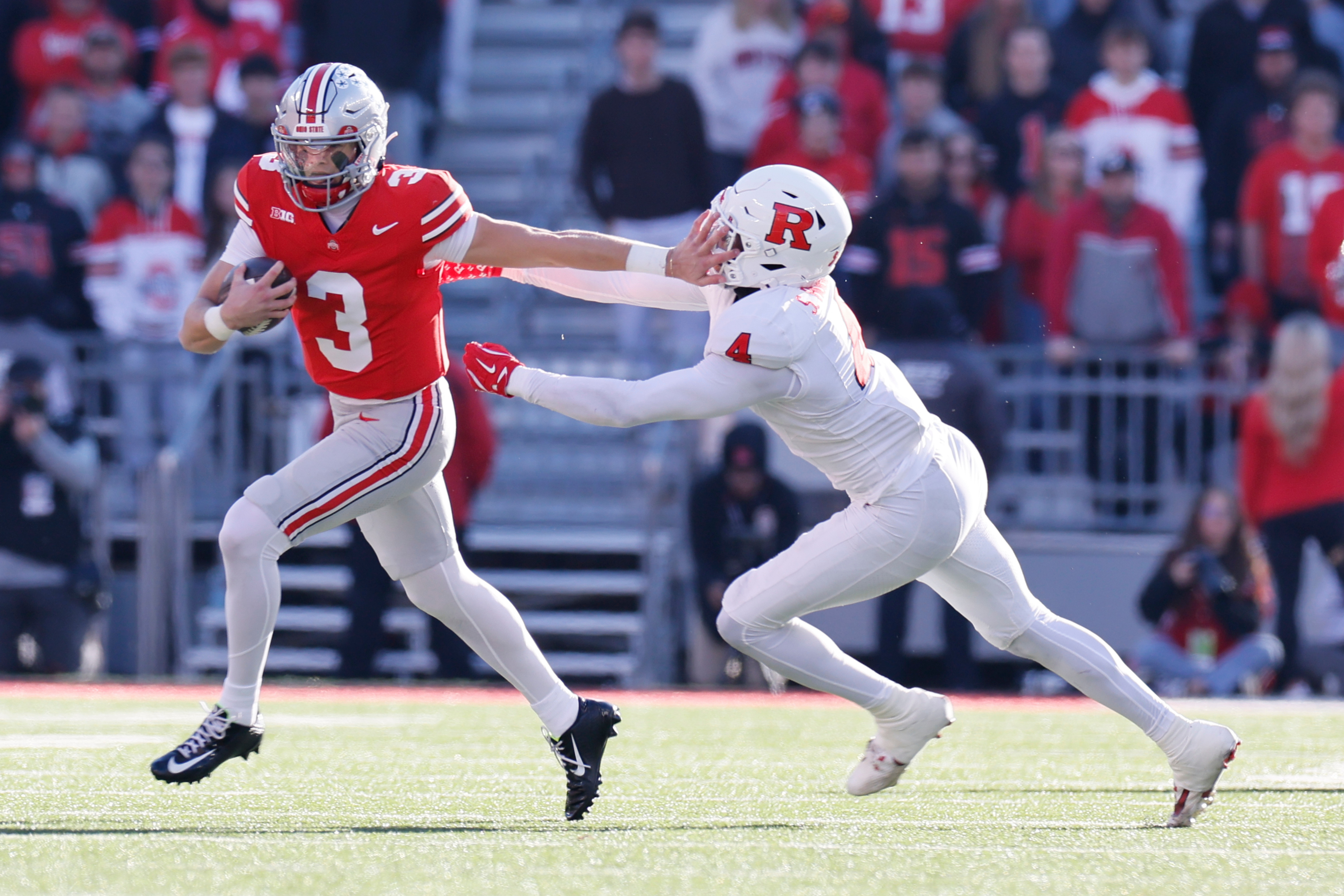 Ohio State quarterback Lincoln Kienholz, left, stiff arms Rutgers linebacker Sam Robinson during the second half of an NCAA college football game, Saturday, Nov. 22, 2025, in Columbus, Ohio. 
