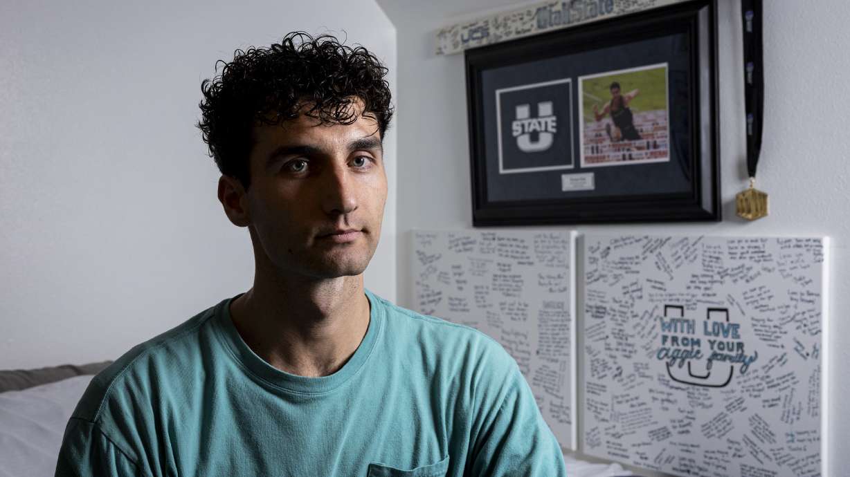 Roman Ruiz poses for a portrait beside memorabilia from his days competing at Utah State University in his bedroom at his family’s home in Pasco, Wash., on Nov. 13.