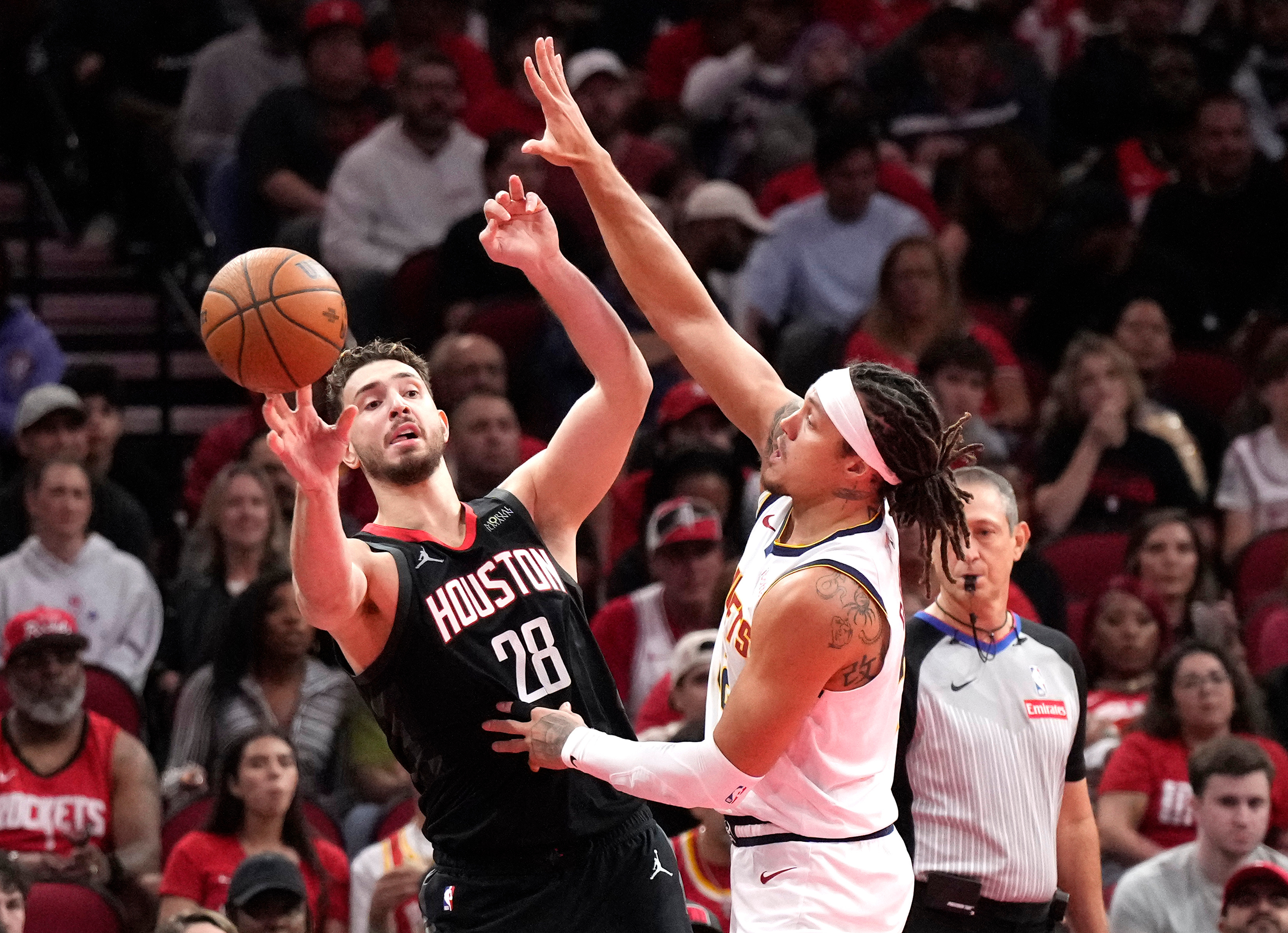 Houston Rockets center Alperen Sengun (28) passes the ball against Denver Nuggets forward Aaron Gordon during the first half of an NBA Cup basketball game, Friday, Nov. 21, 2025, in Houston. 