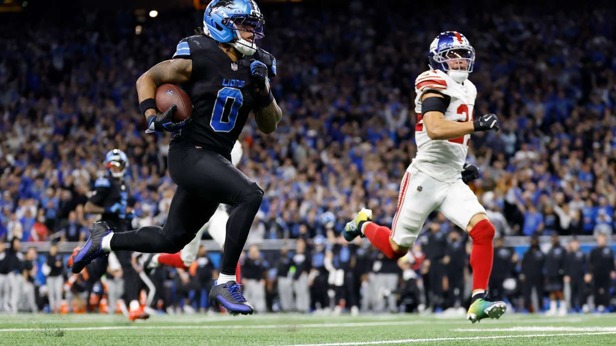 Detroit Lions running back Jahmyr Gibbs (0) runs past New York Giants safety Dane Belton (24) for a touchdown in overtime of an NFL football game in Detroit, Sunday, Nov. 23, 2025.
