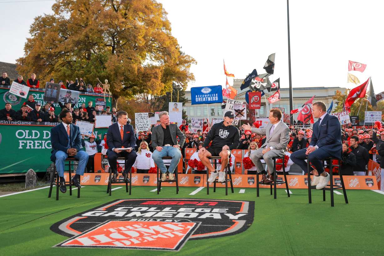 “College GameDay” host Rece Davis, second left, and analysts Desmond Howard, left, Pat McAfee, center left, Nick Saban, second right, and Kirk Herbstreit, right, speak with Utah Football Head Coach Kyle Whittingham, center right, during ESPN’s “College GameDay” in the President's Circle at the University of Utah in Salt Lake City on Nov. 1.