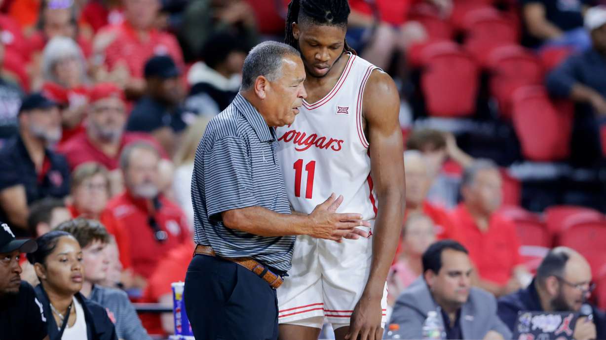 Houston head coach Kelvin Sampson, left, talks with forward Joseph Tugler (11) at the bench during the second half of an NCAA college basketball exhibition game against Mississippi State, Sunday, Oct. 26, 2025, in Rosenberg, Texas.