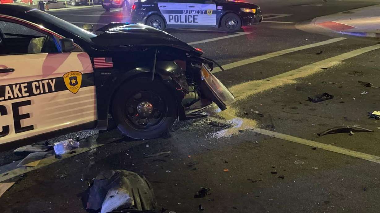 A Salt Lake police officer's patrol car was hit Sunday by a woman who was allegedly distracted by her phone and ran a red light.