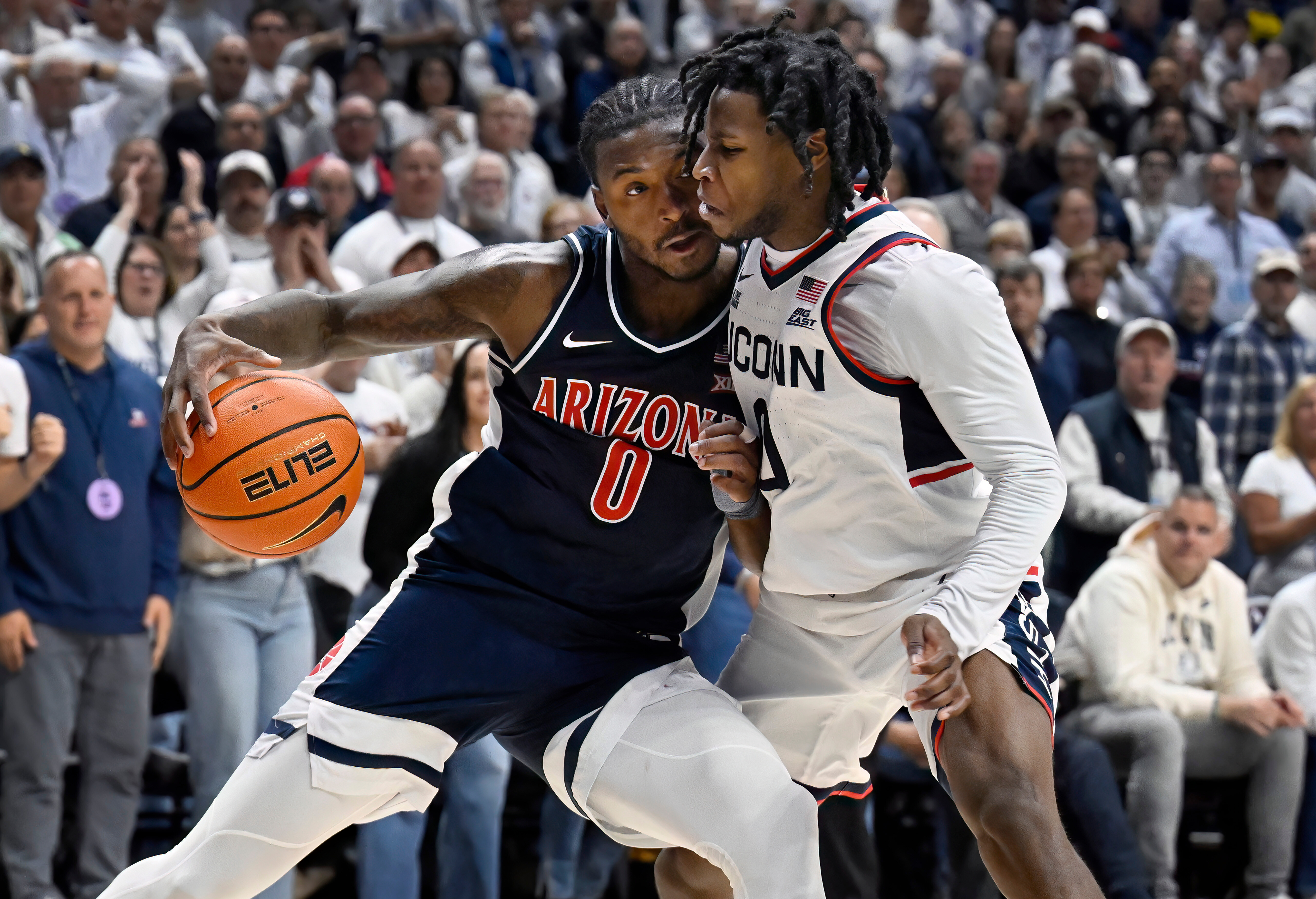 Arizona guard Jaden Bradley (0) is guarded by UConn guard Malachi Smith in the second half of an NCAA college basketball game, Wednesday, Nov. 19, 2025, in Storrs, Conn. 