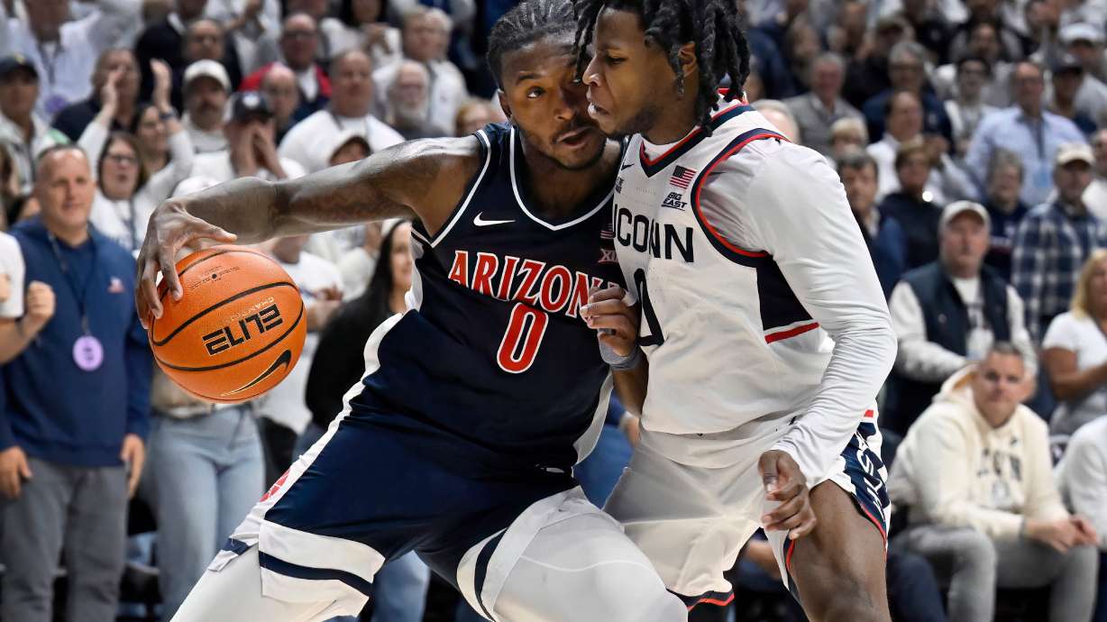 Arizona guard Jaden Bradley (0) is guarded by UConn guard Malachi Smith in the second half of an NCAA college basketball game, Wednesday, Nov. 19, 2025, in Storrs, Conn.